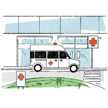 Uma ambulância em frente a um hospital.