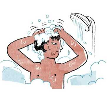 Um homem debaixo de um chuveiro a lavar o cabelo.
